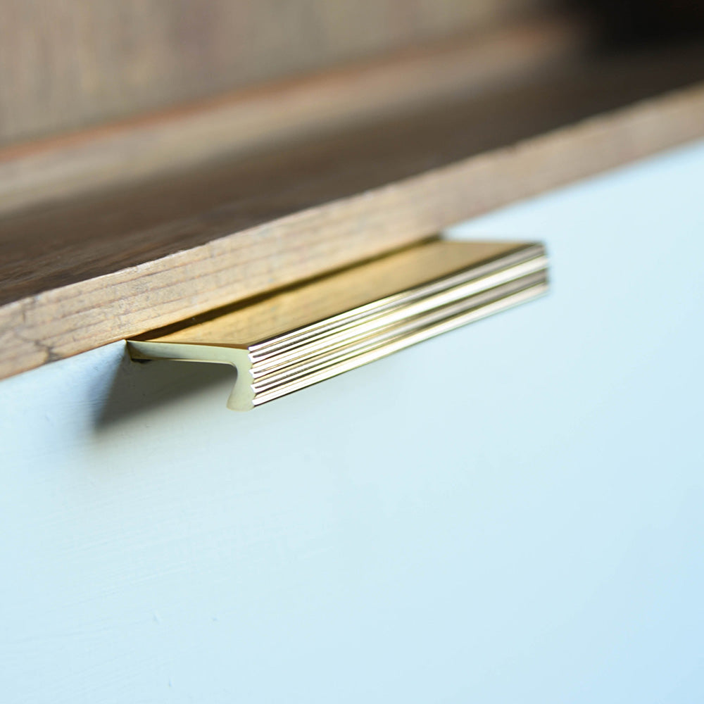 Solid brass Reeded Cabinet Edge Pull on a drawer.