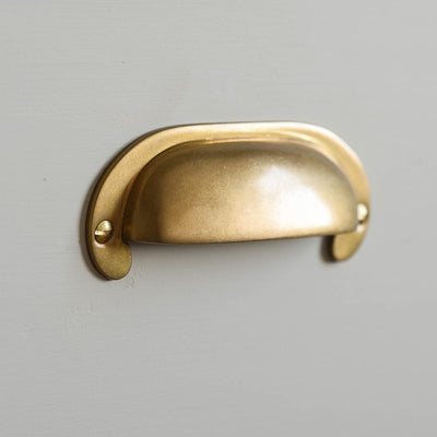 Large Curved Hooded Pull in aged brass finish.