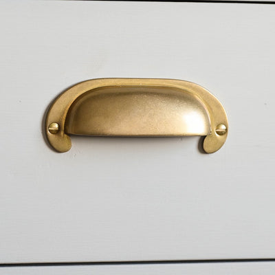 Front view of Large Curved Hooded Pull in aged brass finish.