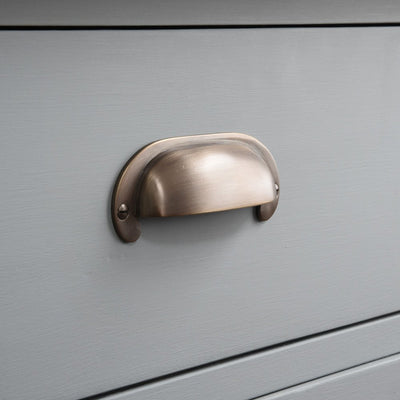 Side on view of Large Curved Hooded Pull in distressed antique brass finish.