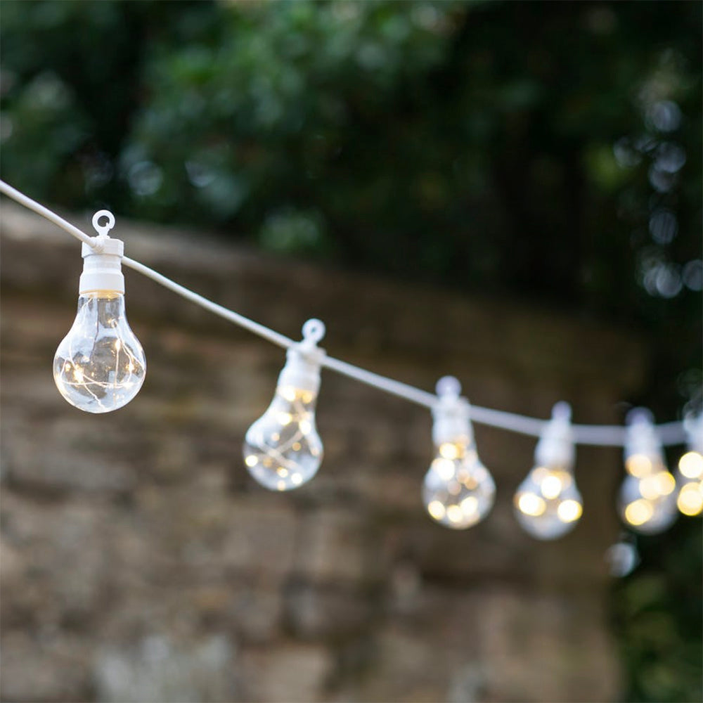 Festoon lightbulbs containing LED fairy lights on white wire