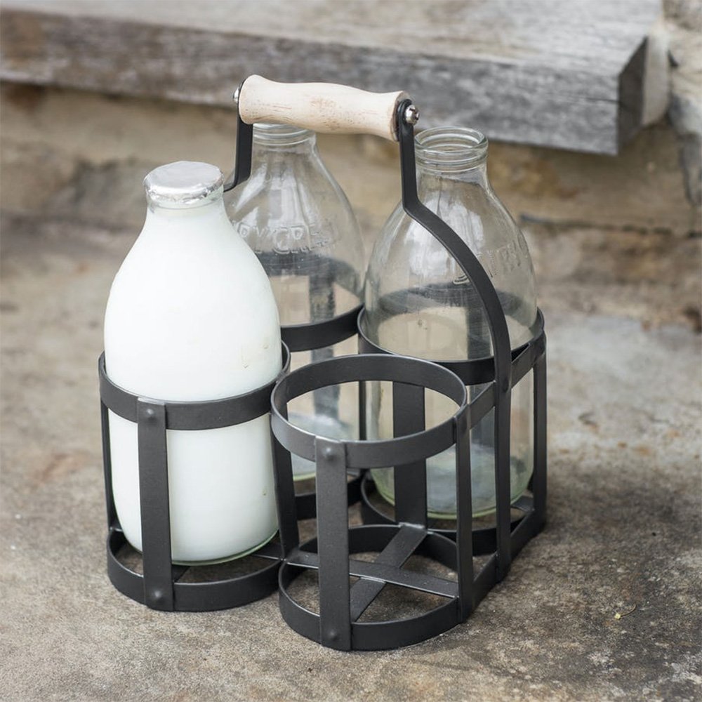 Milk bottle holder crafted in powder coated steel in a dark carbon grey finish with a wooden handle. Holds four standard 1 pint glass milk bottles