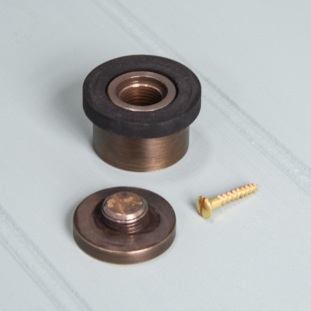 Components of Solid brass Heavy Door Stop in distressed antique finish with rubber rim.