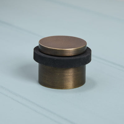 Solid brass Heavy Door Stop in distressed antique finish with rubber rim.
