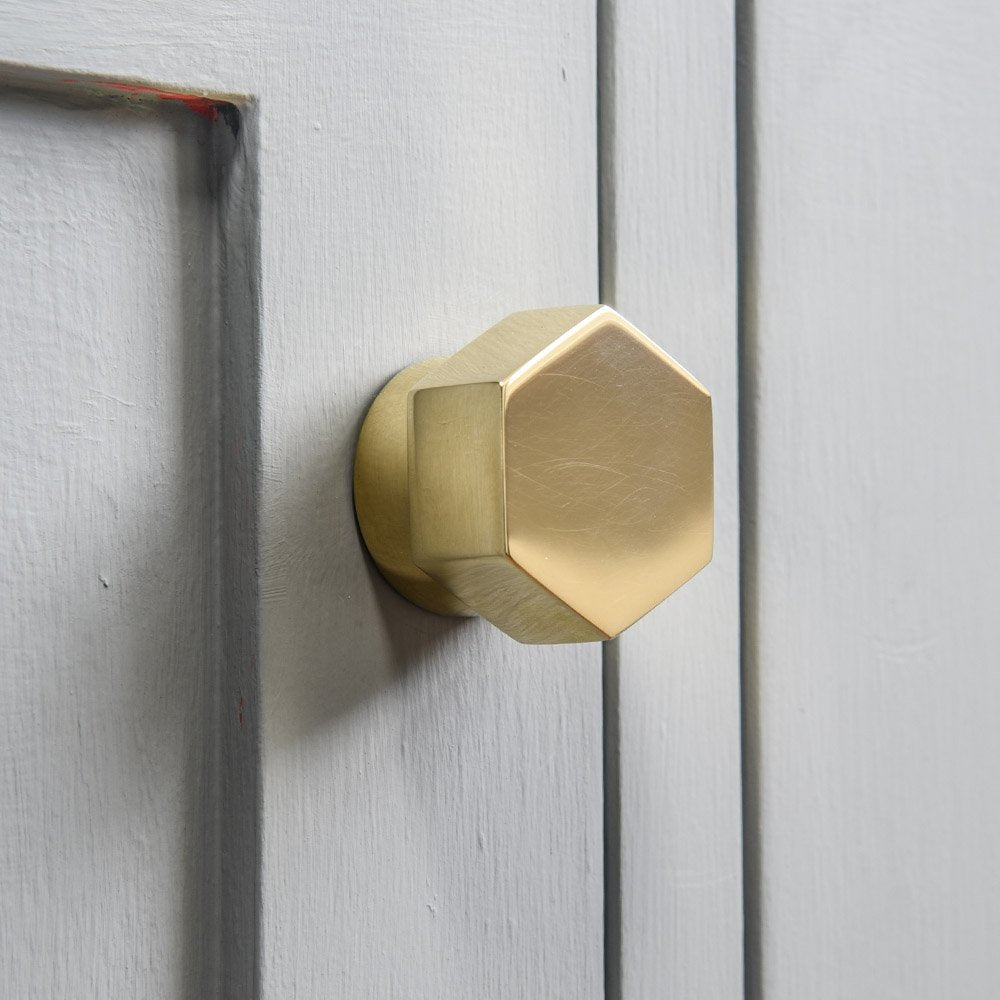 Solid polished brass Hex Cabinet Knob on cupboard door.