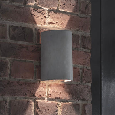 Kew Cylinder Up & Down Light in Raw Concrete Fitted on Brick Wall