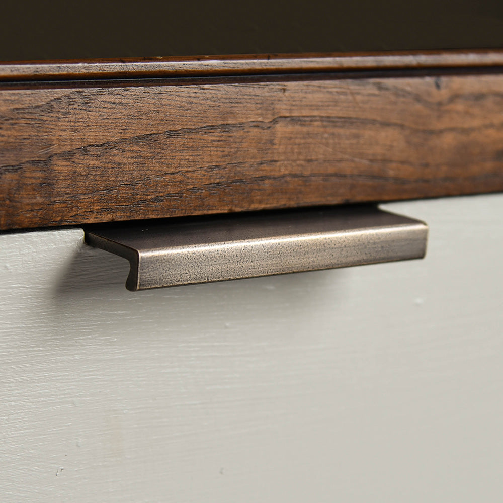 Flat Cabinet Edge Pull in distressed antique brass on drawer