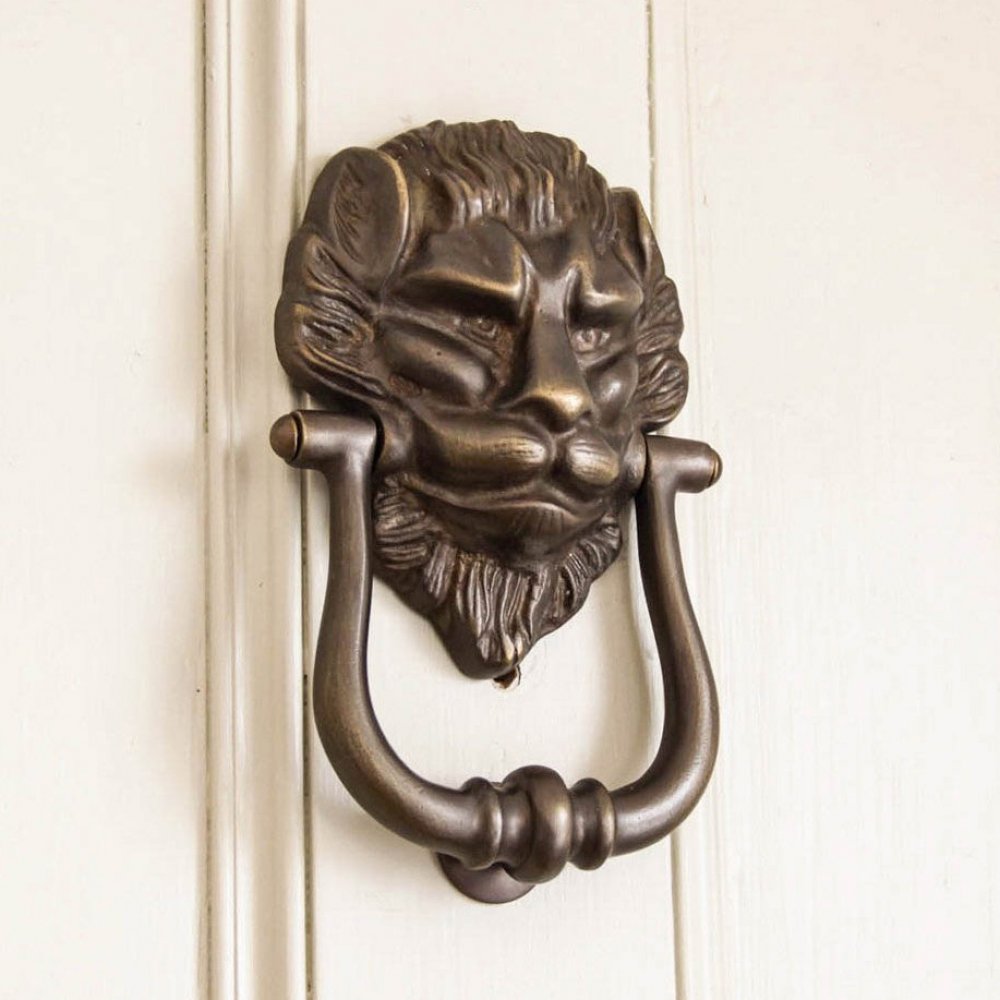 Large Distressed Antique Brass Lion Door Knocker on front door.