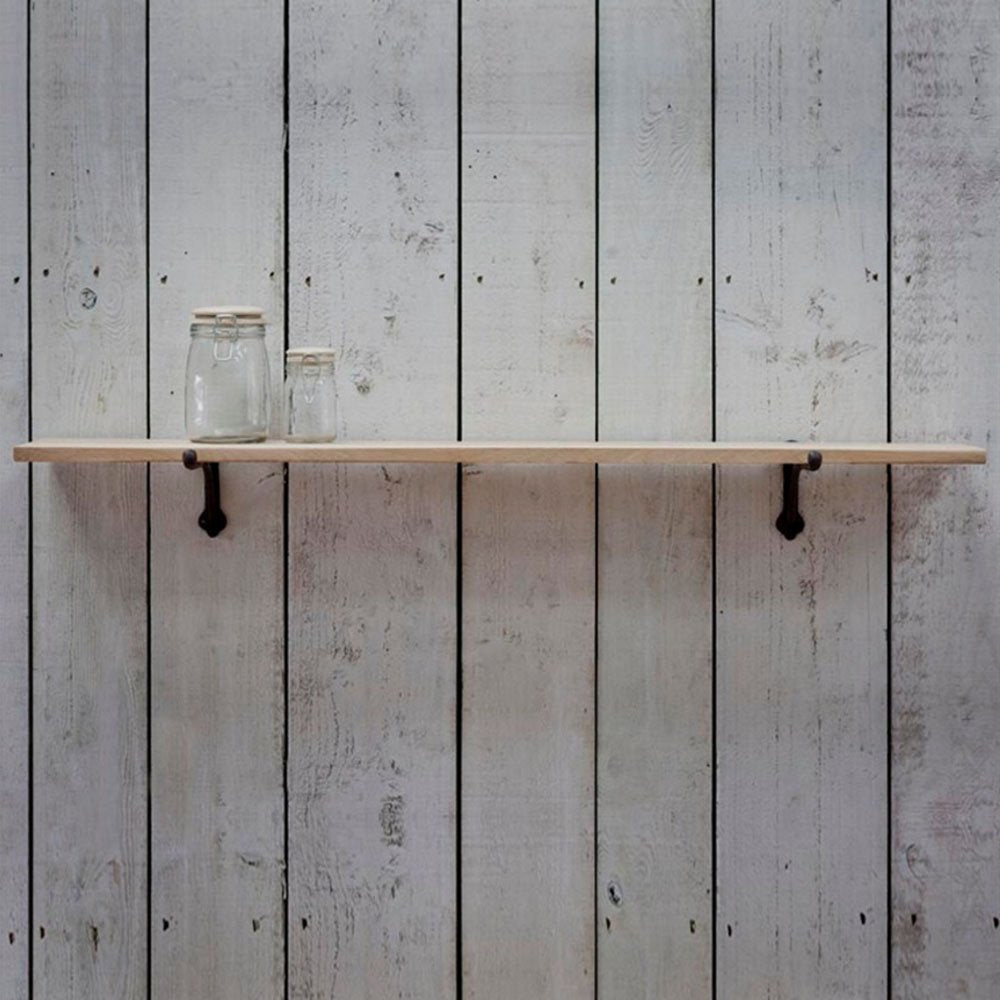 A simple raw oak shelf with a pair of cast iron brackets
