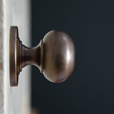 Close up of Large Bun Door Knobs in distressed antique finish.