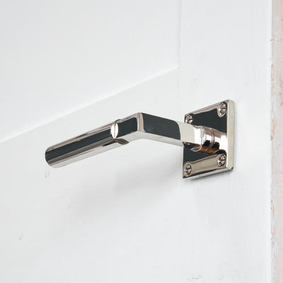 Solid brass Gyllyng Lever Handle on Square Rose with polished nickel finish mounted on door, upward facing view.