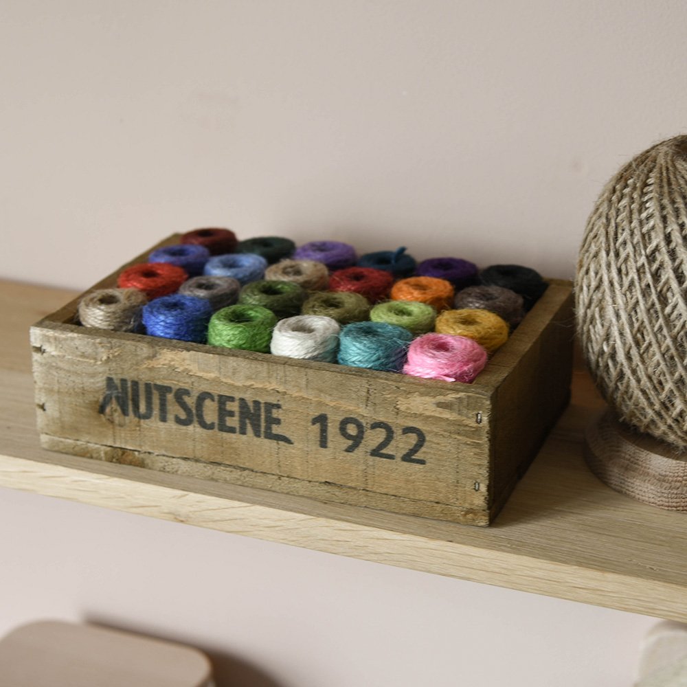 Wooden box filled with multi-coloured spools of twine