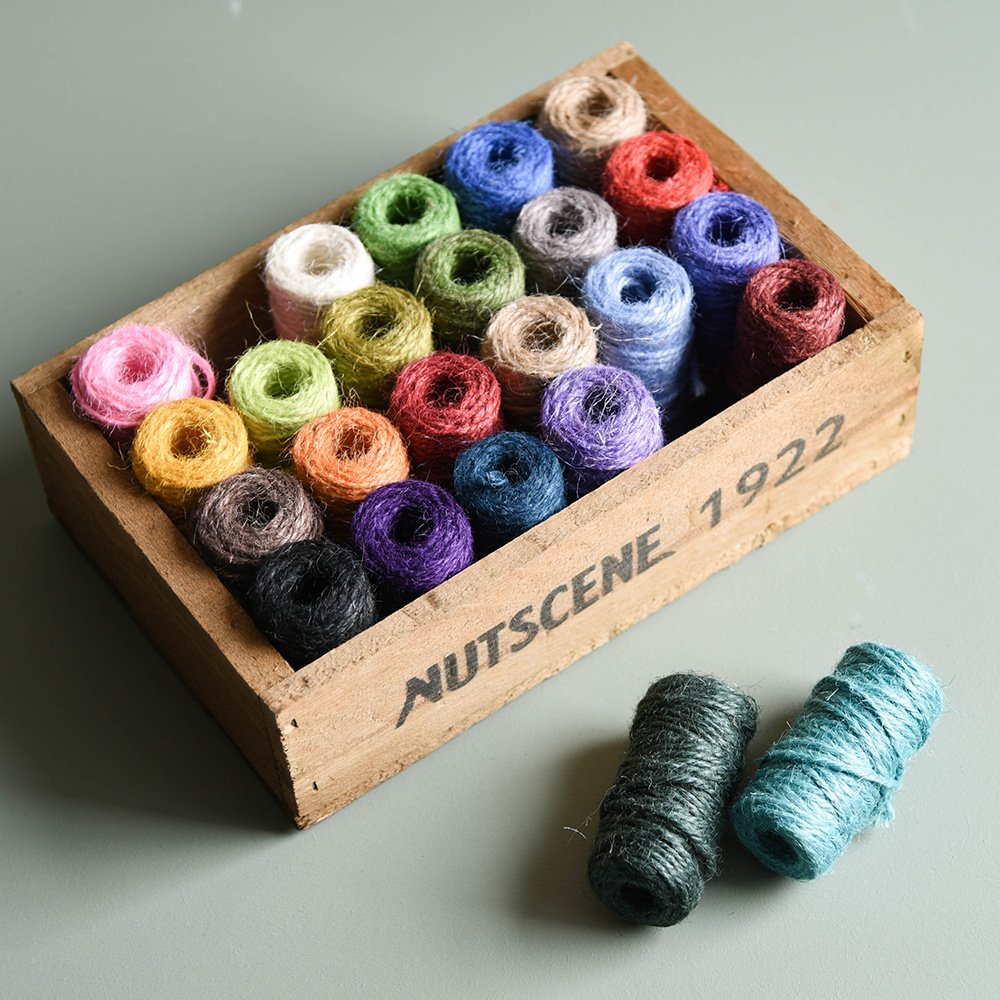 Top view of multi-coloured twine in wooden box