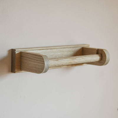 Oak kitchen roll holder mounted on a wall