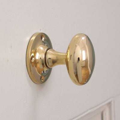 Brass oval door knob on round backplate