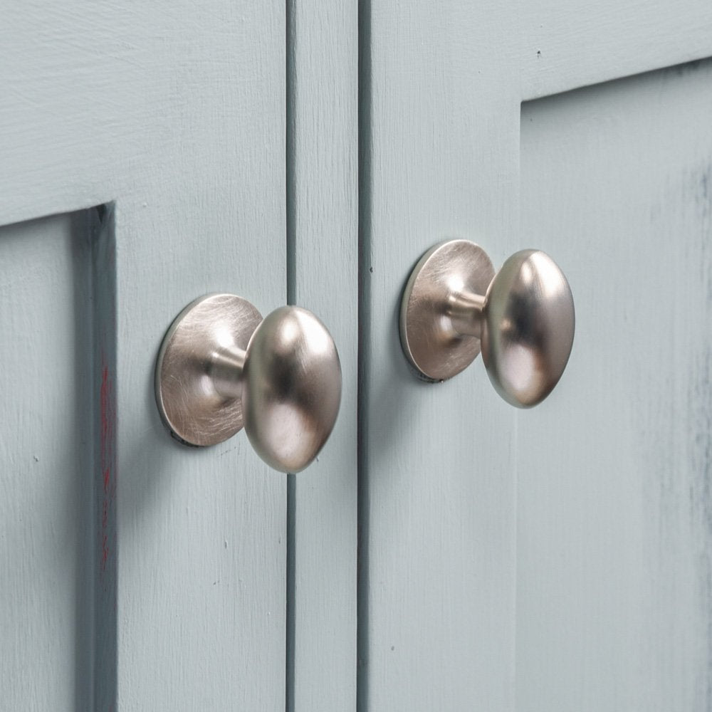 Two Oval Satin Nickel Cabinet Knobs on cupboard doors.