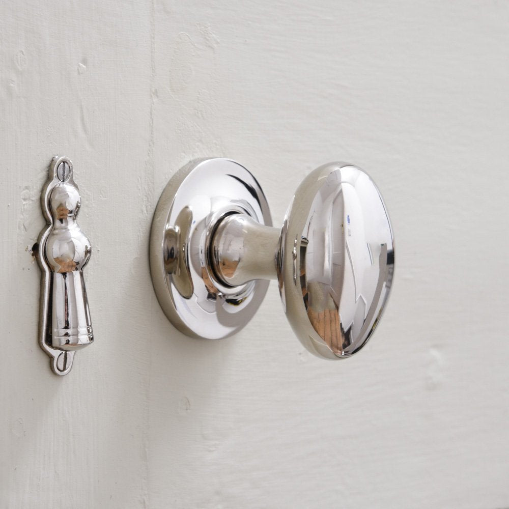 Polished nickel oval shaped door knob on round roseplate