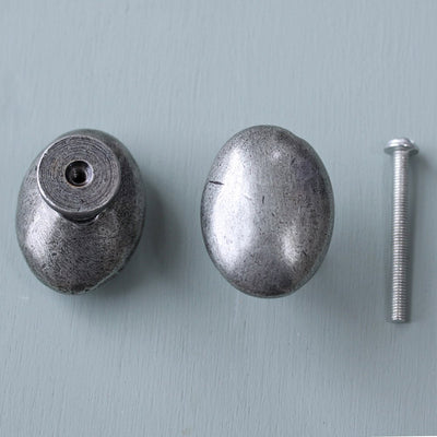 An image showing the front and back of an oval cabinet knob with screw bolt