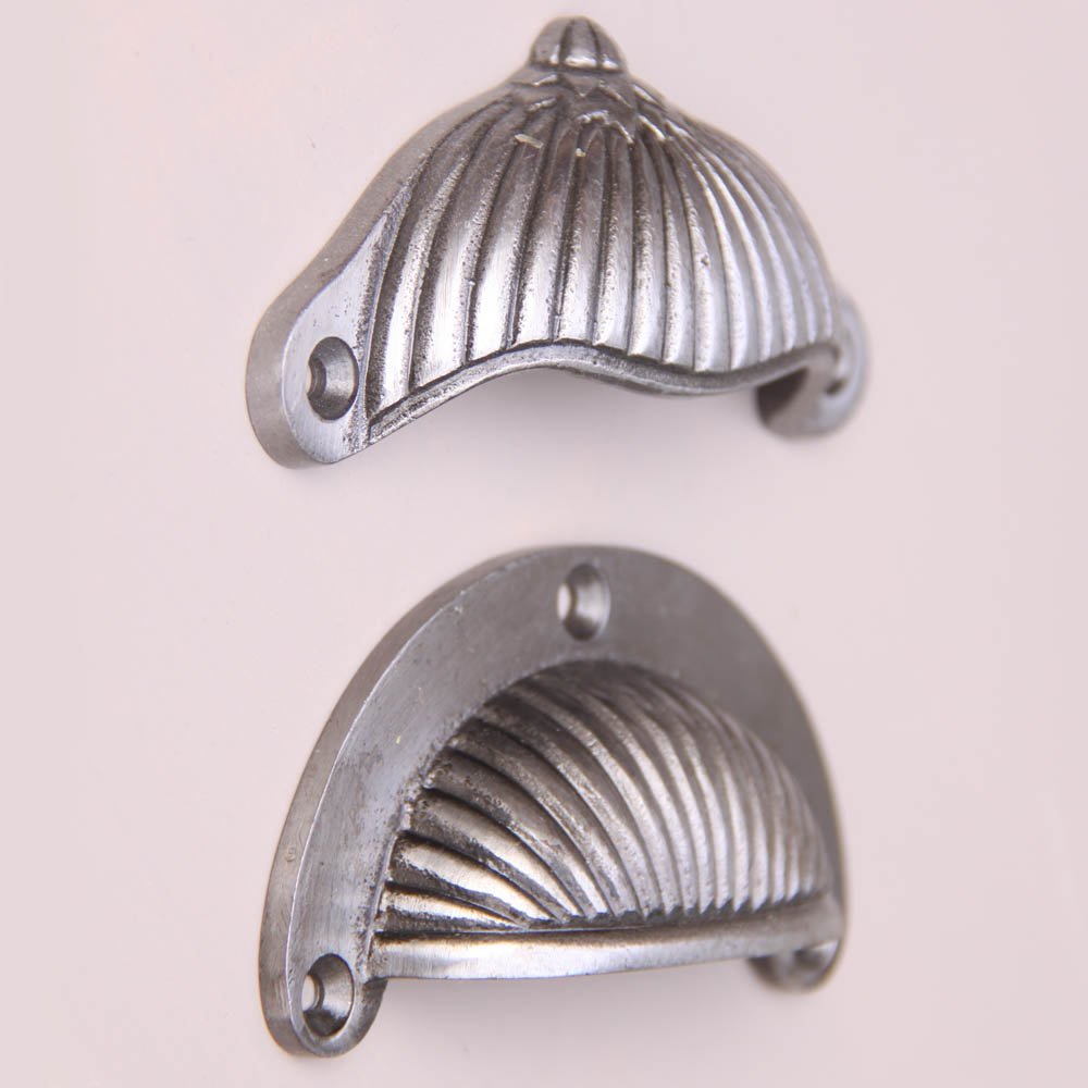 Two designs of Reeded hooded drawer pulls in natural iron finish. A decorative finished pull above and a smooth rounded pull below