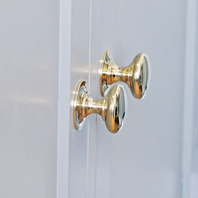 Side profile of two brass cabinet knobs on a cabinet