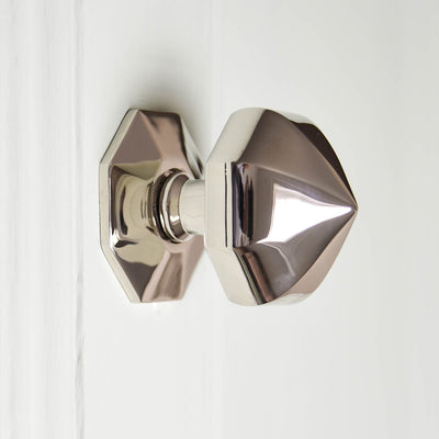 Solid brass Pointed Octagonal Door Pull in Polished Nickel plated finish in warm lighting.