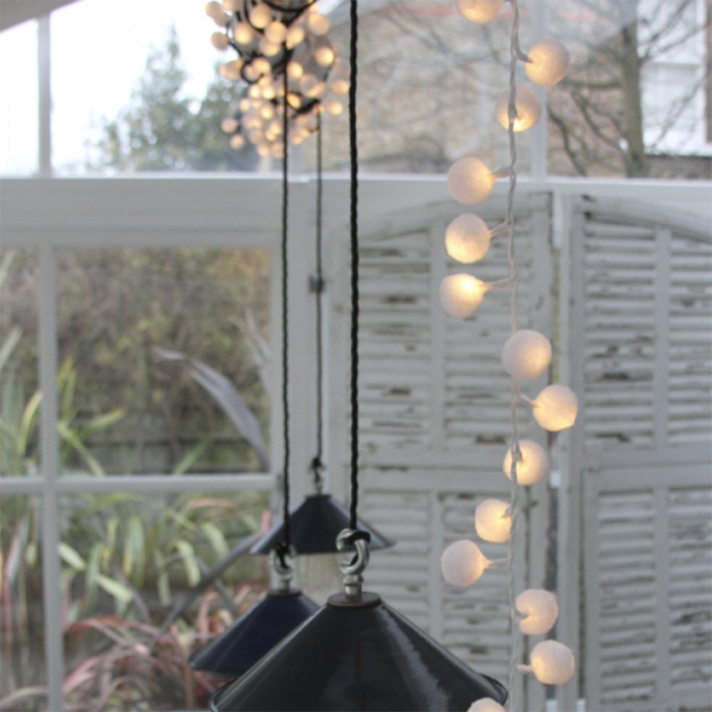 Light up pom pom string lights wrapped around pendant lights