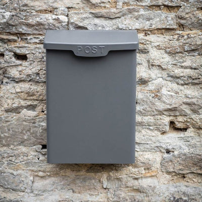 Charcoal grey post box with 'post' embossed in capital letters across the front of the lid.