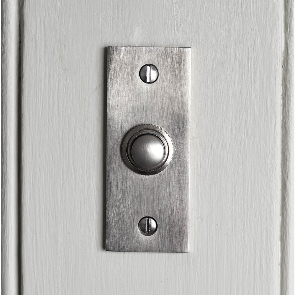 Solid brass Rectangular Bell Push plated in Satin Nickel finish on white door.
