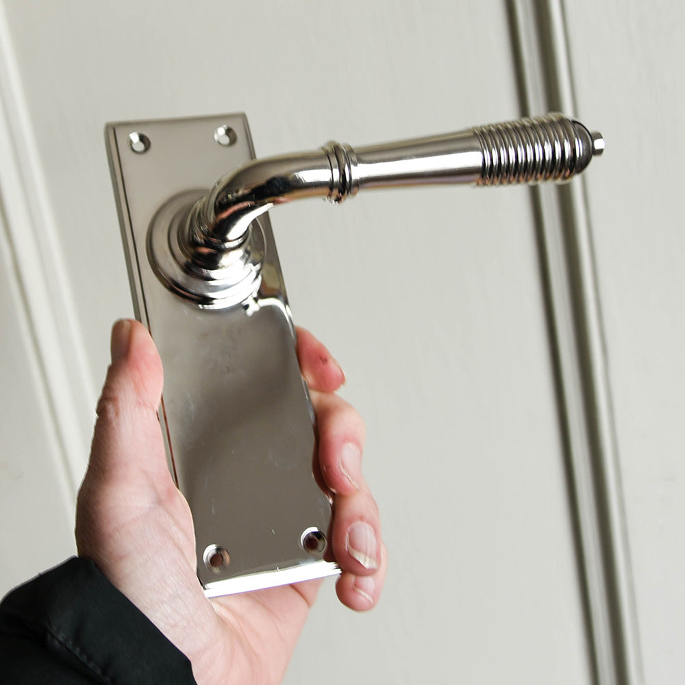 A reeded lever handle with a plain backplate in a  polished NICKEL FINISH
