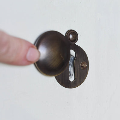 Demonstration of solid brass Plain Round Escutcheon in Distressed Antique finish.