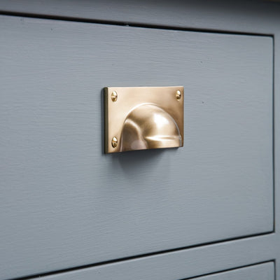 Solid Brass Hooded Drawer Pull in Satin Brass finish on blue drawer.
