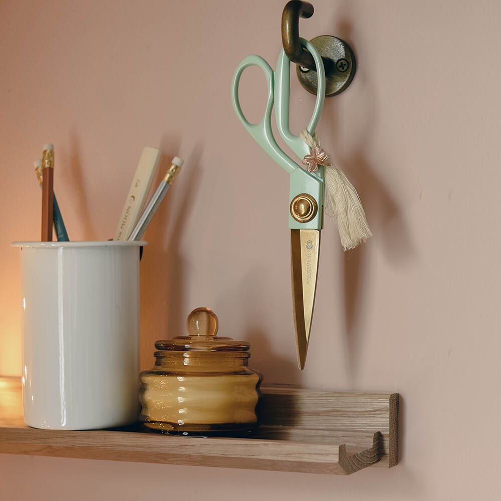 scissors hung above a shelf with other stationery