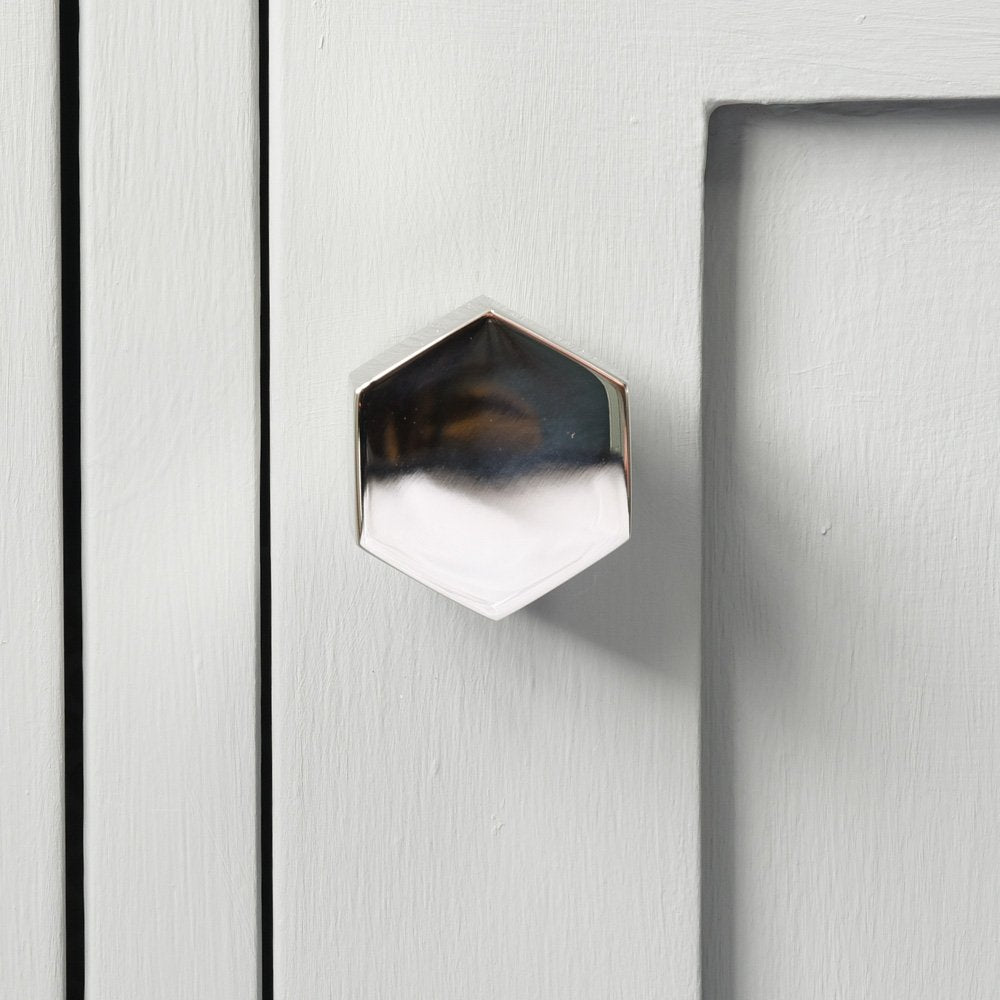 Front-on view of polished nickel Hex Cabinet Knob on cupboard door.