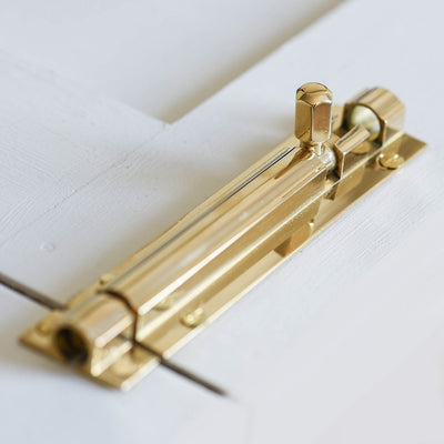 Alternate angle of solid brass Rounded Barrel Bolt on cupboard door.