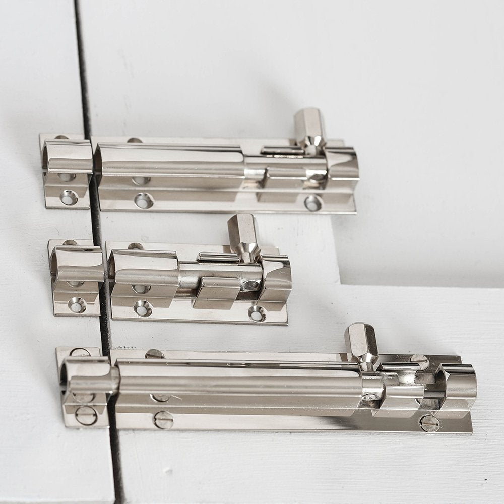 Three sizes of solid brass Rounded Barrel Bolt in Polished Nickel finish on cupboard door.