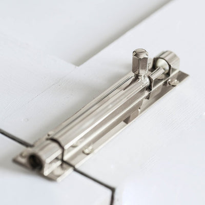 Alternate angle of solid brass Rounded Barrel Bolt in Polished Nickel finish on cupboard door.
