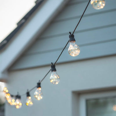 String of 20 solar festoon lights with copper LEDs inside light bulbs and black wire.