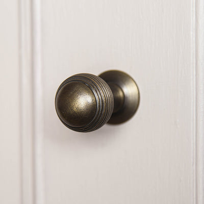 Alternate angle of elegant solid brass Reeded Beehive Cabinet Knob with distressed antique finish.