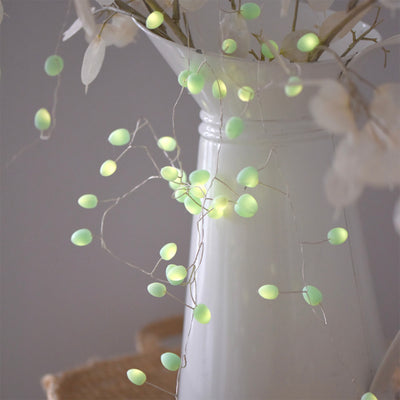 Detail of Mint Green Teardrop Shaped Fairy Lights Wrapped Around Jug and Foliage