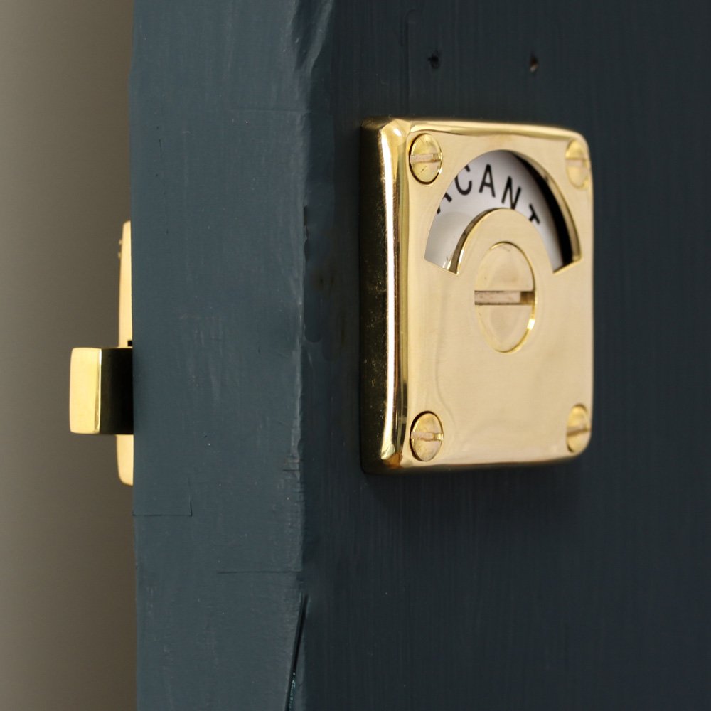 Polished brass bathroom door lock with 'vacant/engaged' display dial. Showing both sides of door.