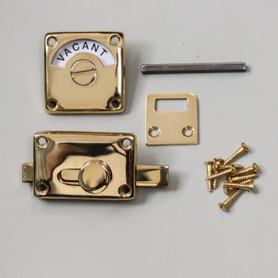 Polished brass bathroom door lock with 'vacant/engaged' display dial. Showing complete set of components.