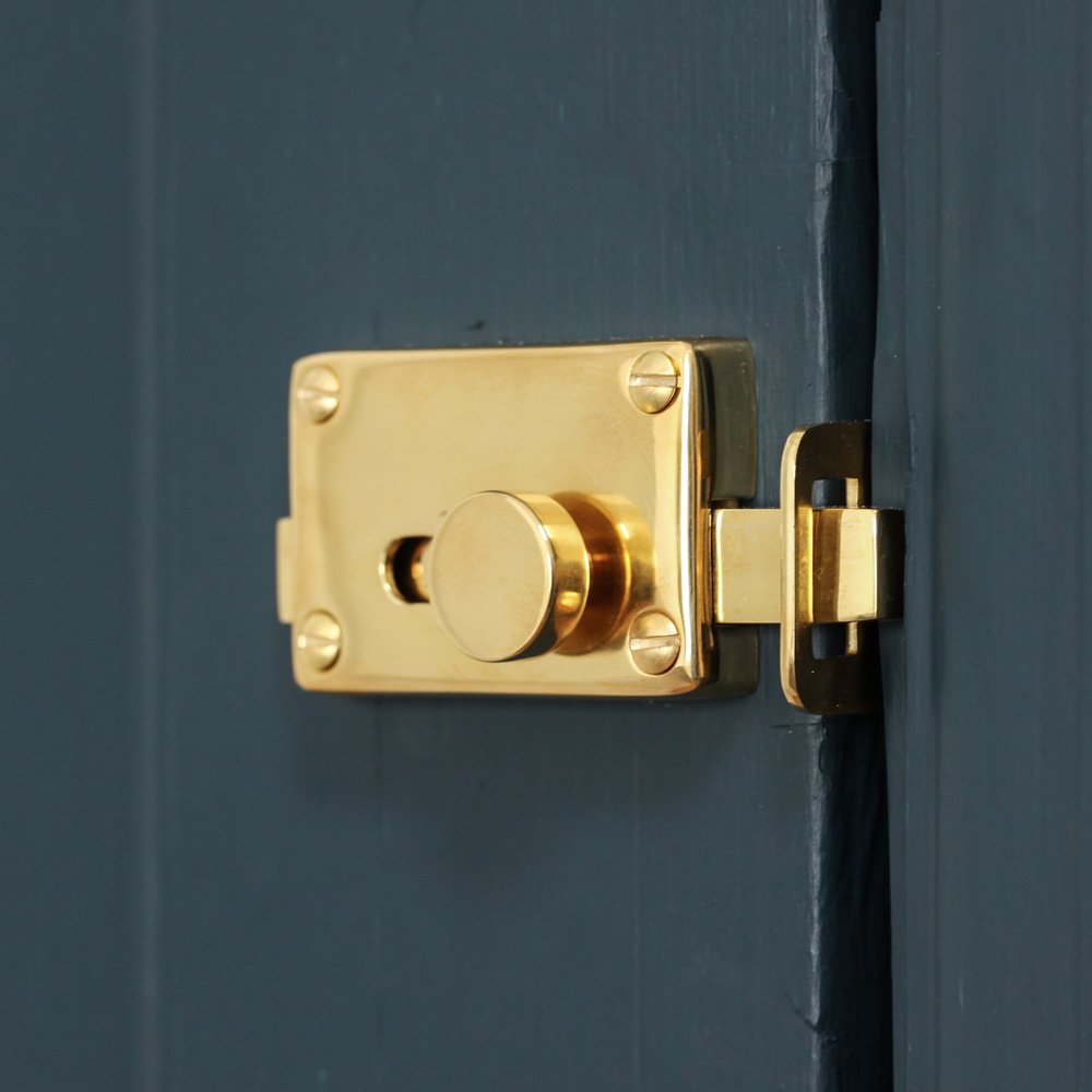 Polished brass bathroom door lock with 'vacant/engaged' display dial. Showing the inside of the door.