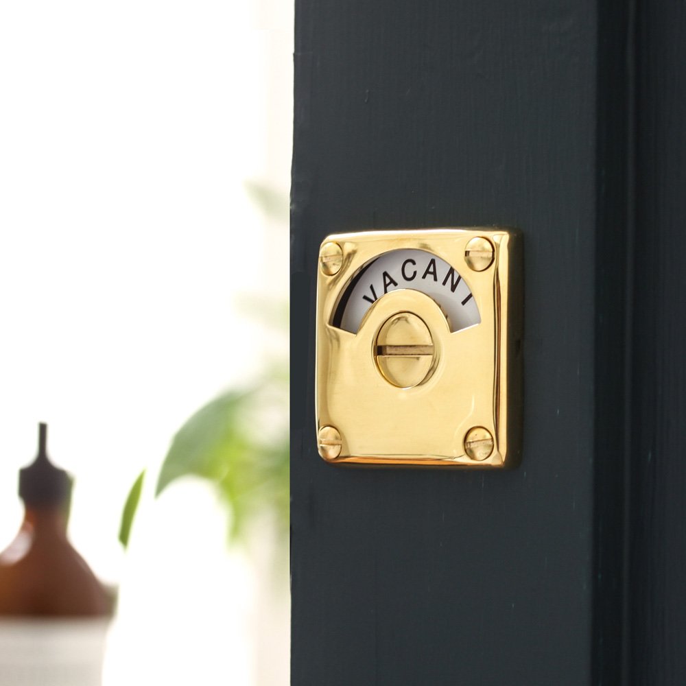 Polished brass bathroom door lock with 'vacant/engaged' display dial