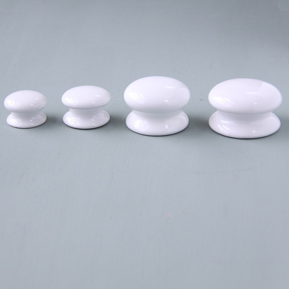 White Ceramic Cabinet Knobs Lined Up in Small, Medium, Large and Extra Large