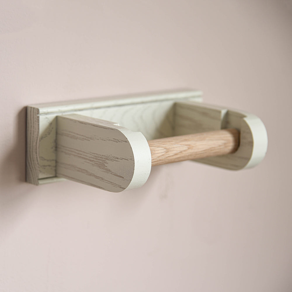 White oak loo roll holder fixed to a wall