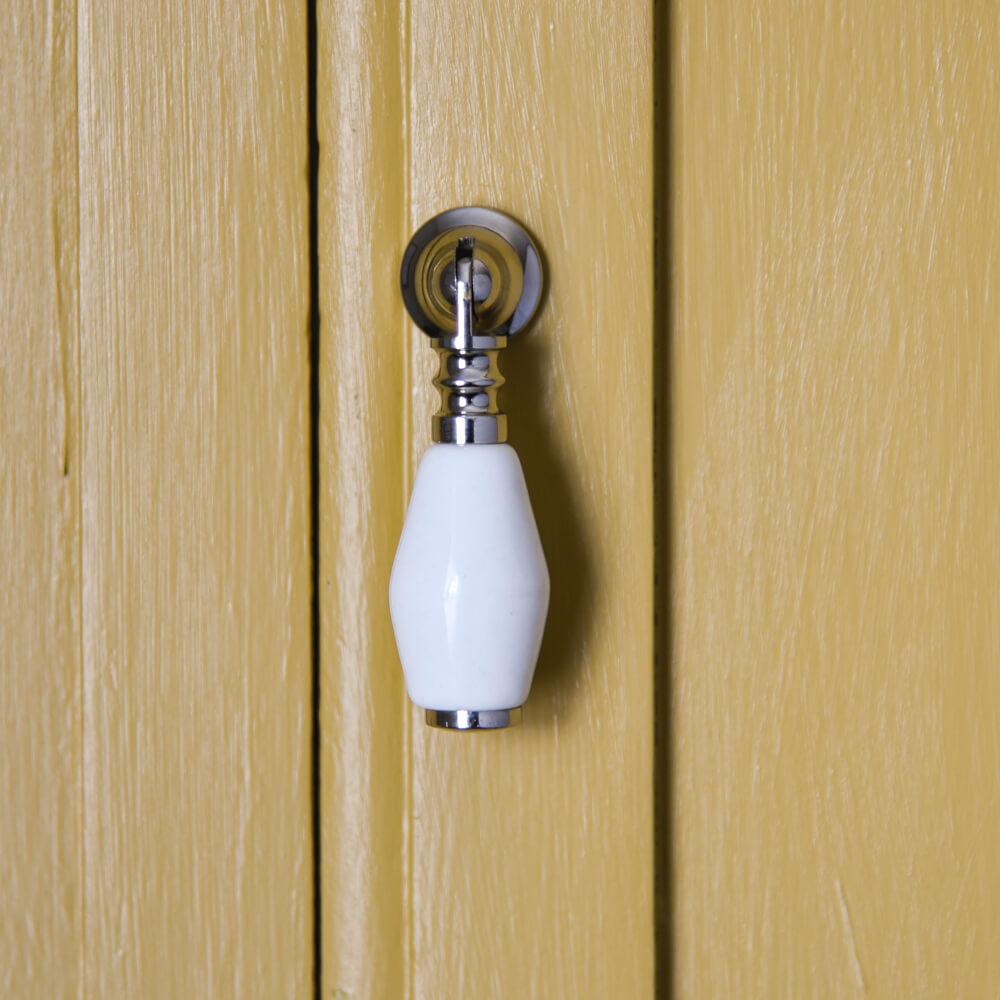 Nickel and white ceramic drop handle on yellow doors