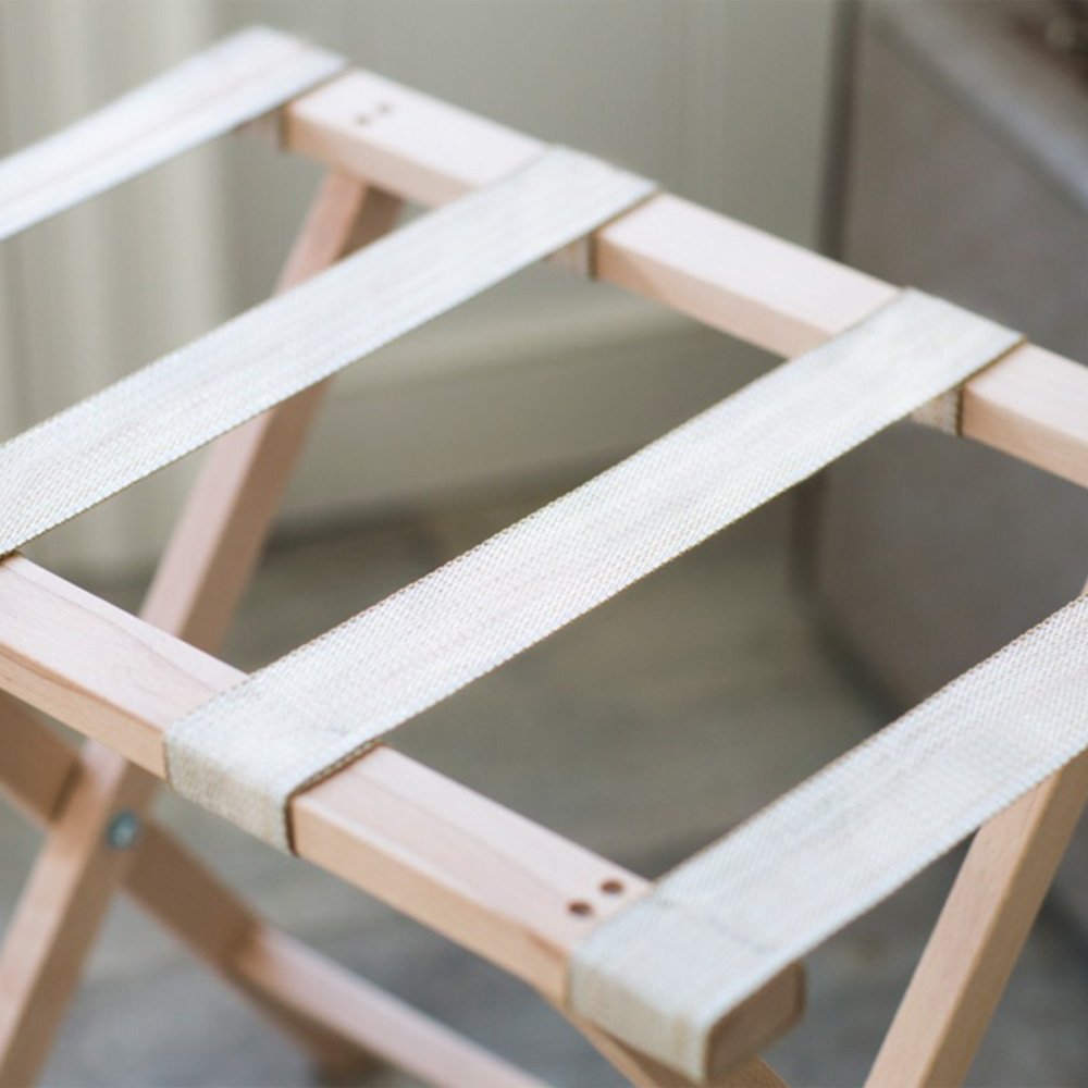 Close up of cream canvas bands on folding wooden luggage rack